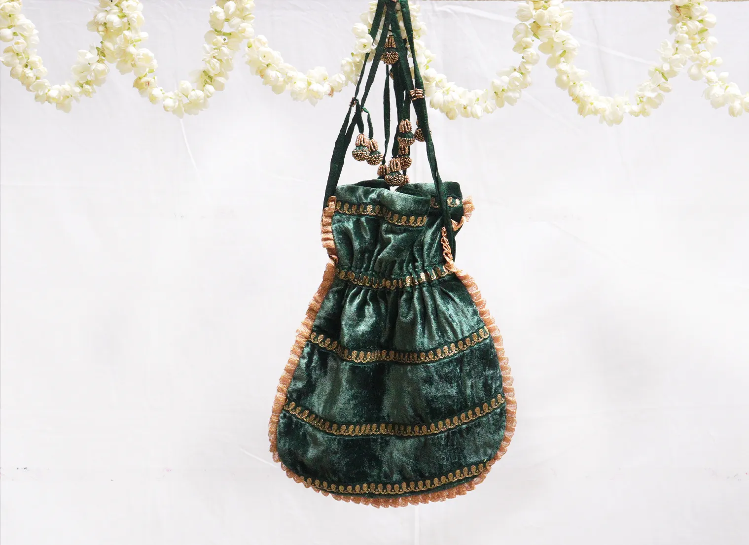 Dark green velvet potli with gold jari embroidery